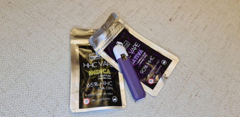 Två påsar för HHC vapes, en öppnad med lila vape liggandes ovanpå.